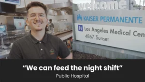 man smiling next to a kaiser permanente sign.
